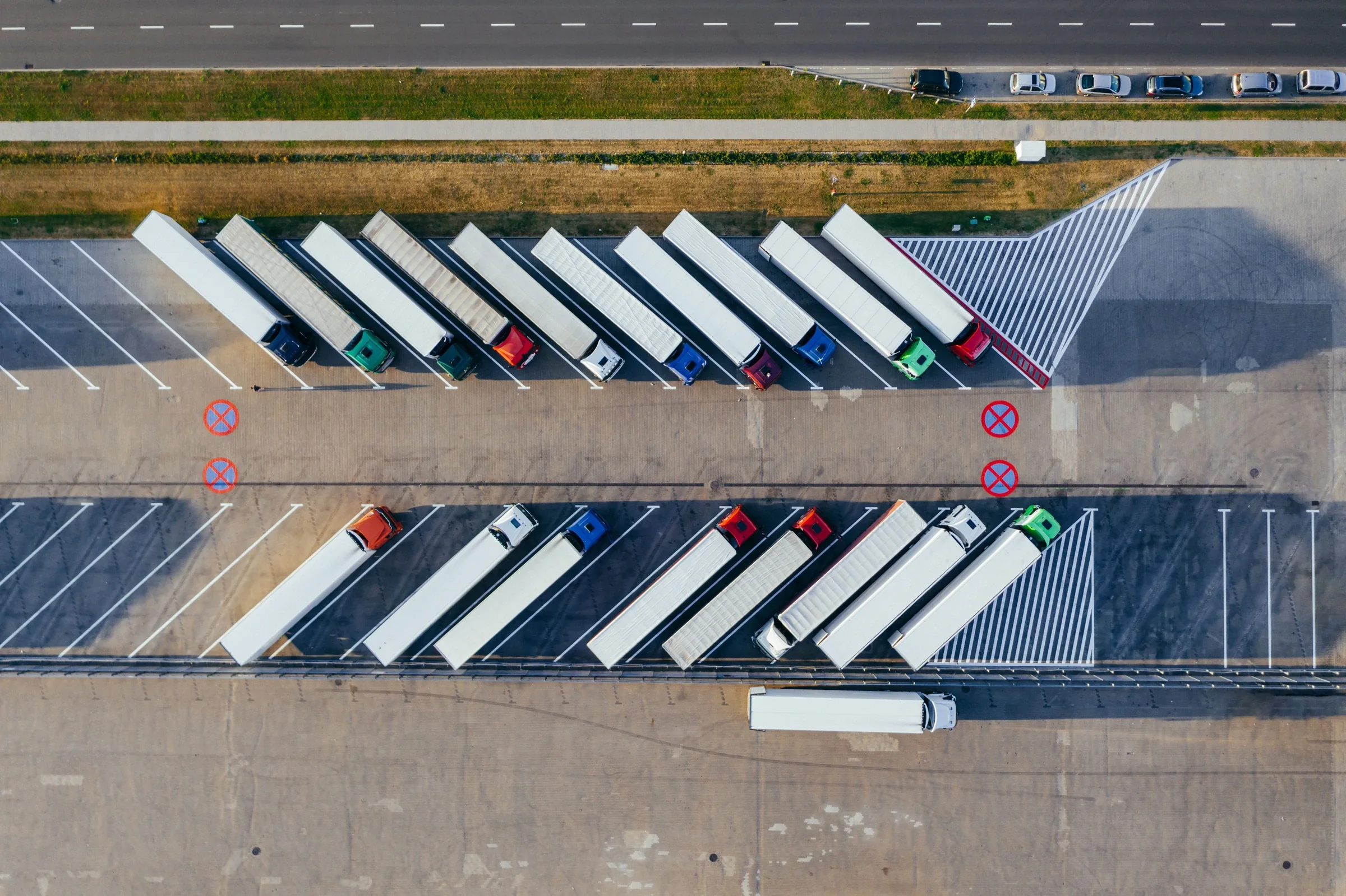 Luftaufnahme geordnet abgestellter Sattelzüge an einem Logistikstandort; Symbolfoto